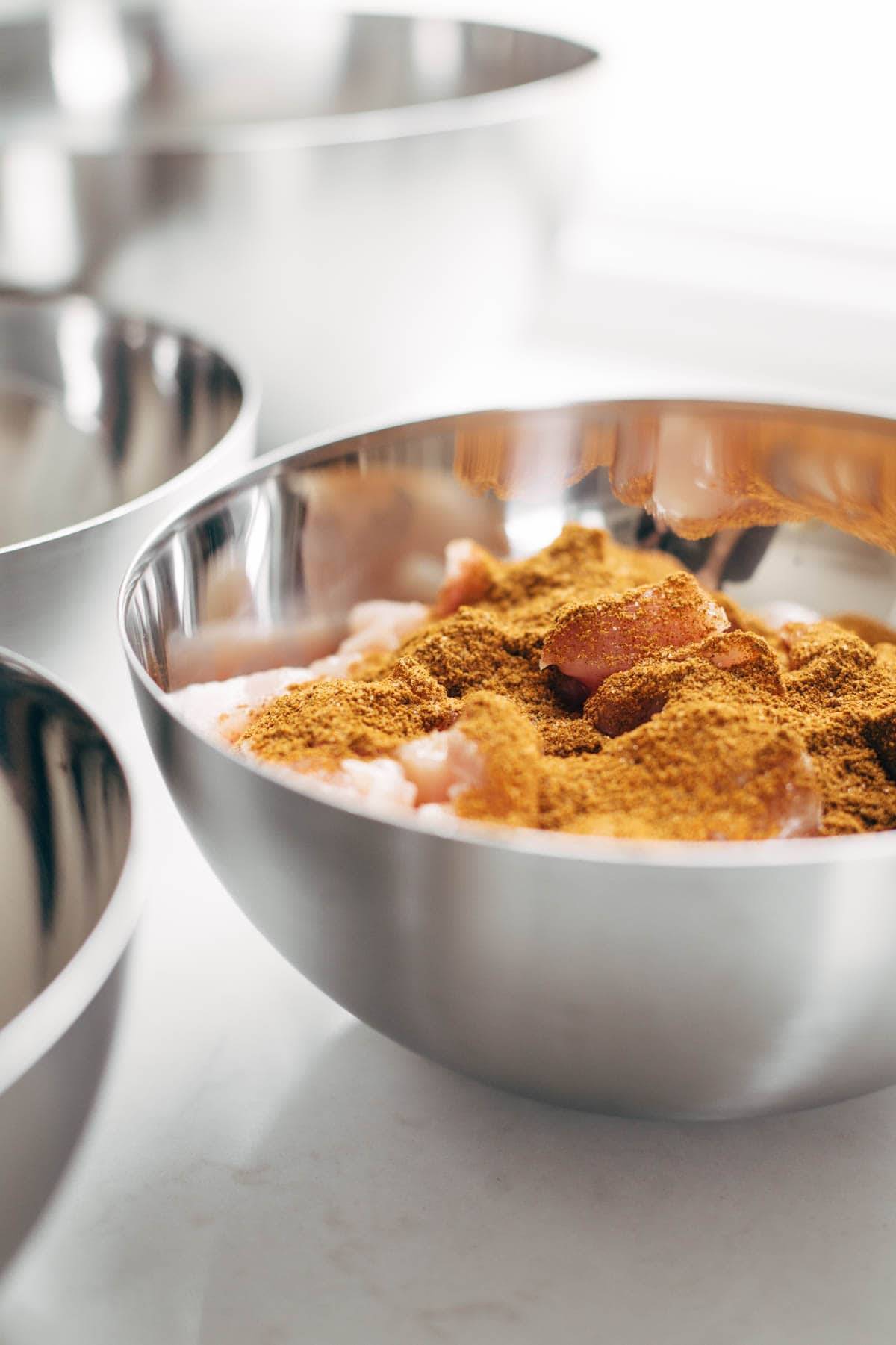 Chicken and spices in a bowl.